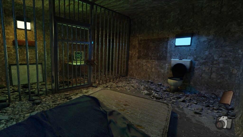 featured image for our news on Mini Escapes: The Below. It shows a prison room with a bed, a toilet and light. Outside the prison is a computer desktop on a table.